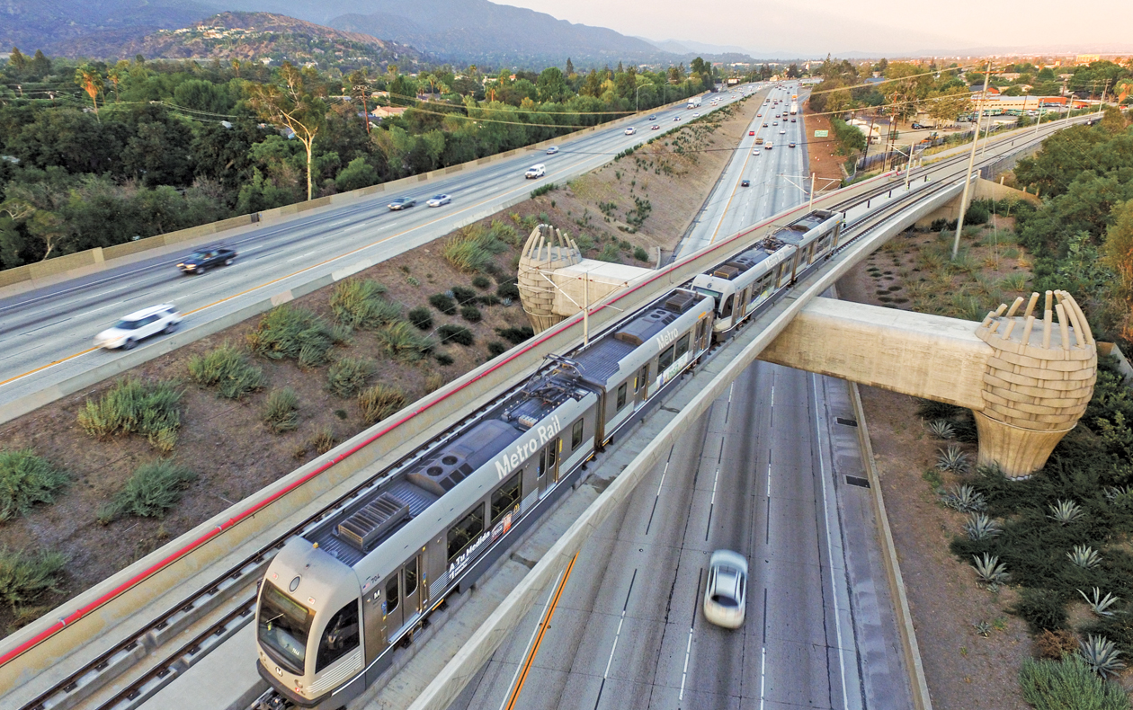 Photo of Metro light rail cars passing over a freeway.